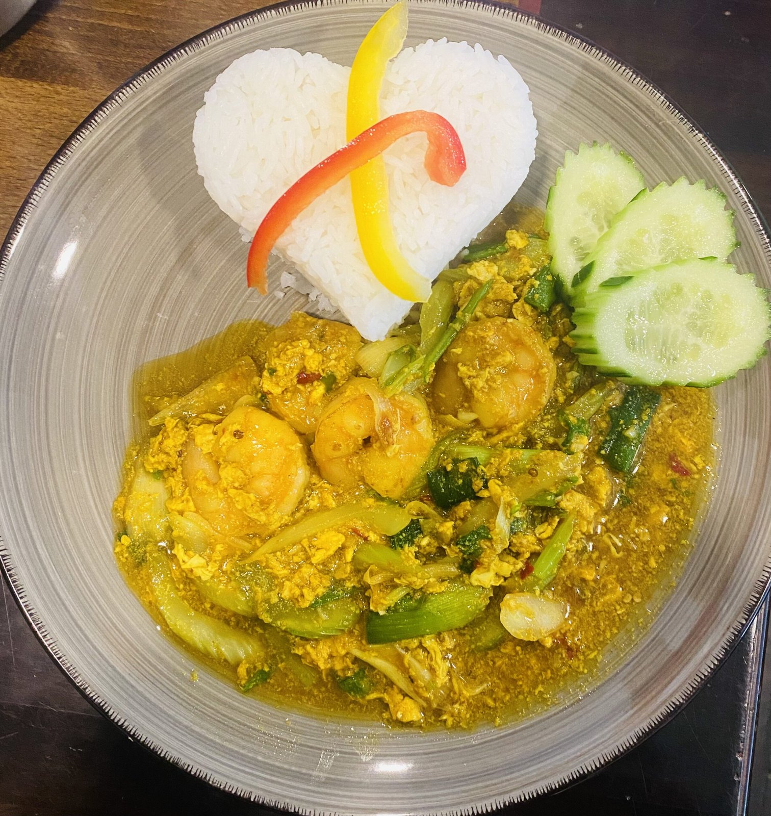 Phad Phongkra Hri Gung: Garnelen mit Currypulver, Ei und Gemüse, Reis in Herzform mit Paprikastreifen, Gurkenscheiben